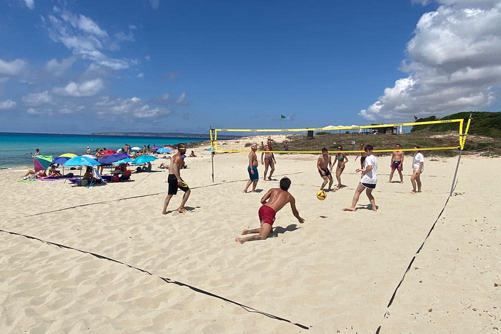 gente en playa de arenals en Formentera jugando a beach volley